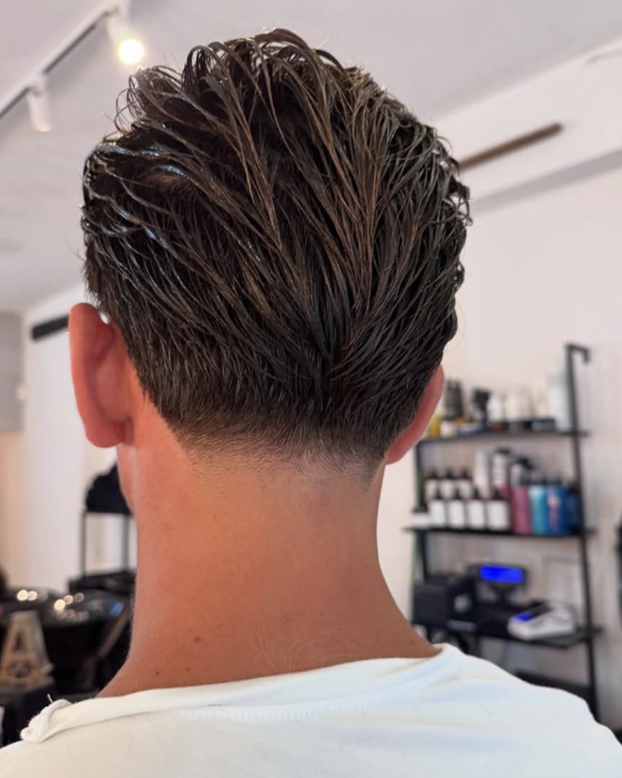 Taglio uomo con nuca sfumata e styling all'indietro